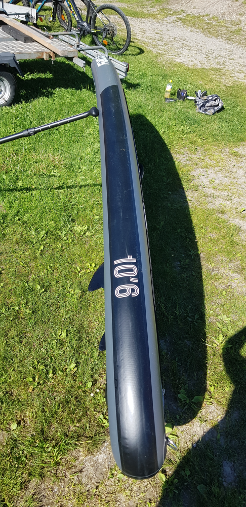 Fullt oppblåst SUP i solen holdt oppreist med en padle